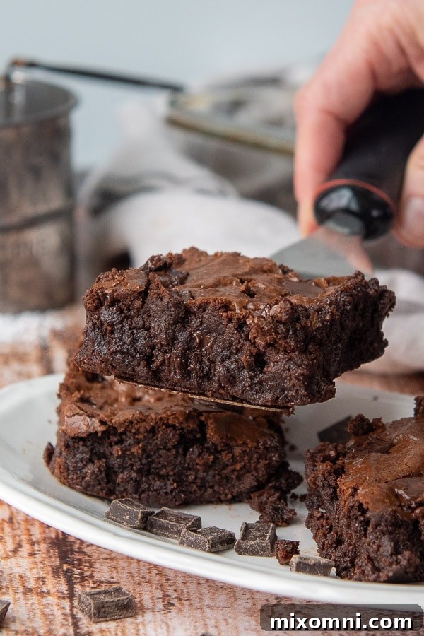 A spatula lifting a single, perfect almond flour brownie, showcasing its rich, fudgy texture.