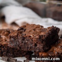 A stack of three rich, fudgy almond flour brownies on a white plate