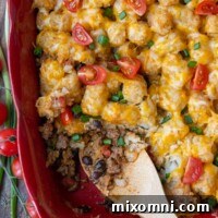 overhead shot of mexican tater tot casserole with a scoop taken out