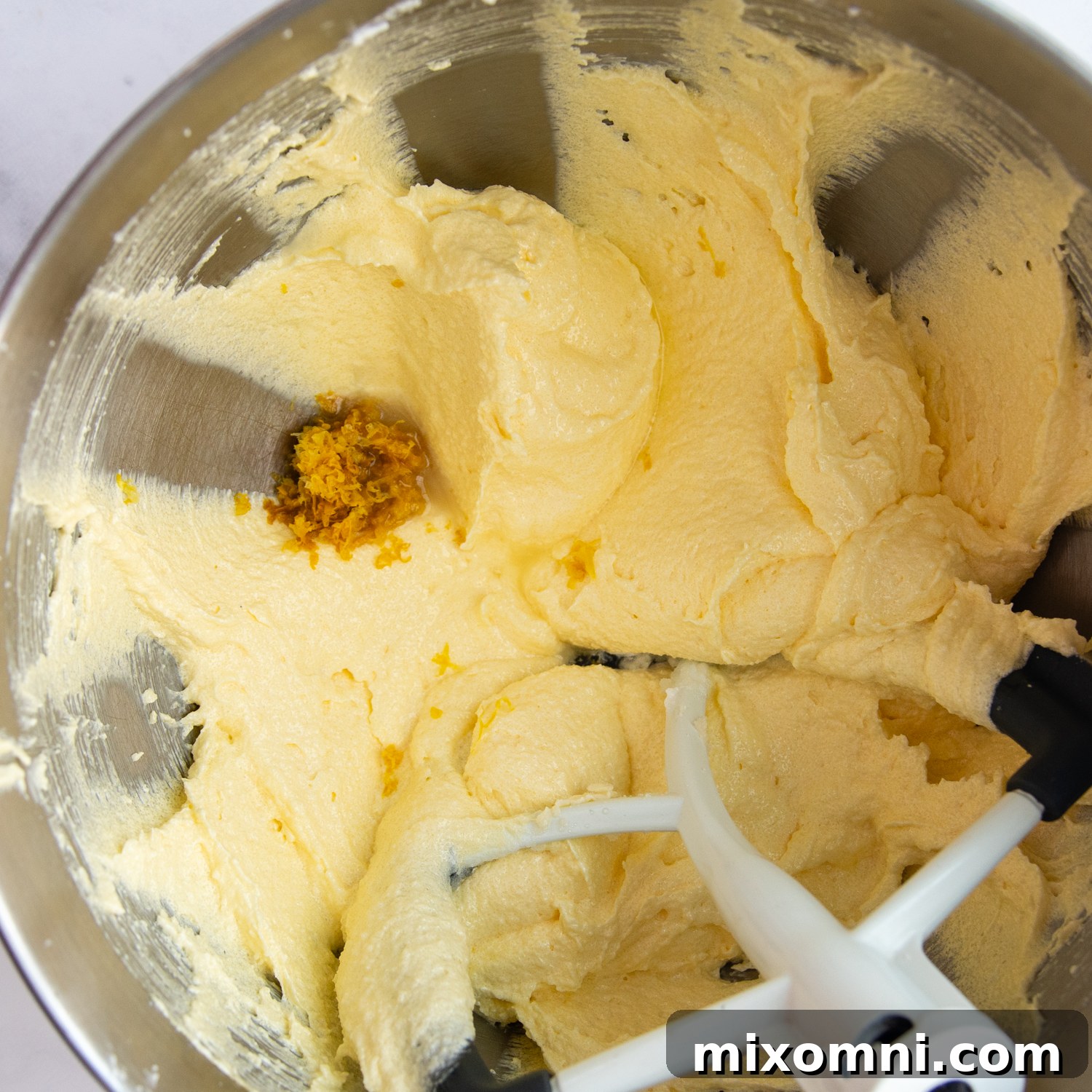 Creamed butter, sugar, and oil mixture in a mixing bowl, showcasing its light and fluffy texture.