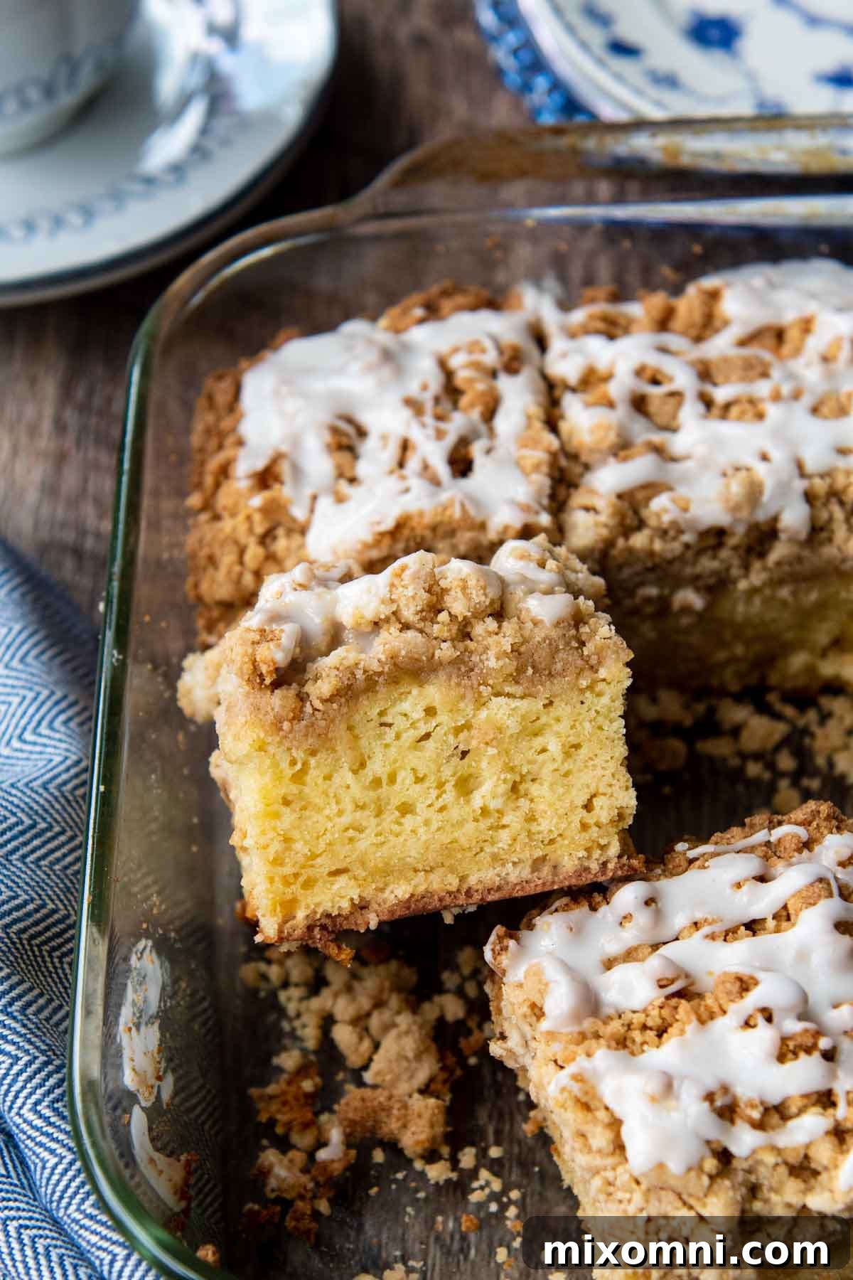 A perfectly baked slice of gluten-free crumb cake resting in the baking pan alongside other slices, ready to be enjoyed.