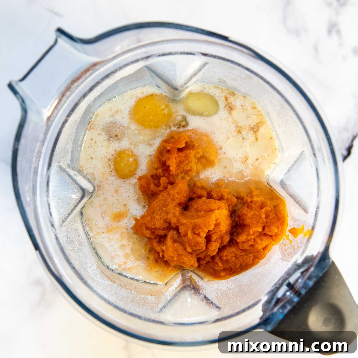 pumpkin puree, along with other wet ingredients being added.