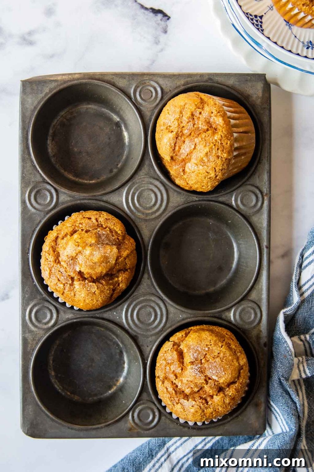 overhead shot of pumpkin oat flour muffins in a vintage muffin pan