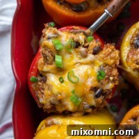 overhead shot of mexican stuffed peppers in a baking dish with a spoon going into one