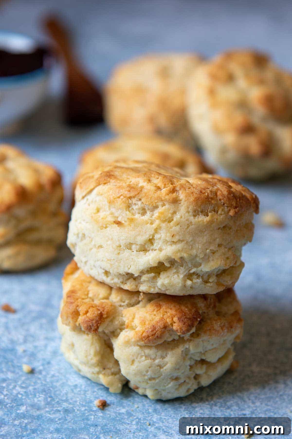 a stack of two gluten free biscuits with more biscuits laying around them