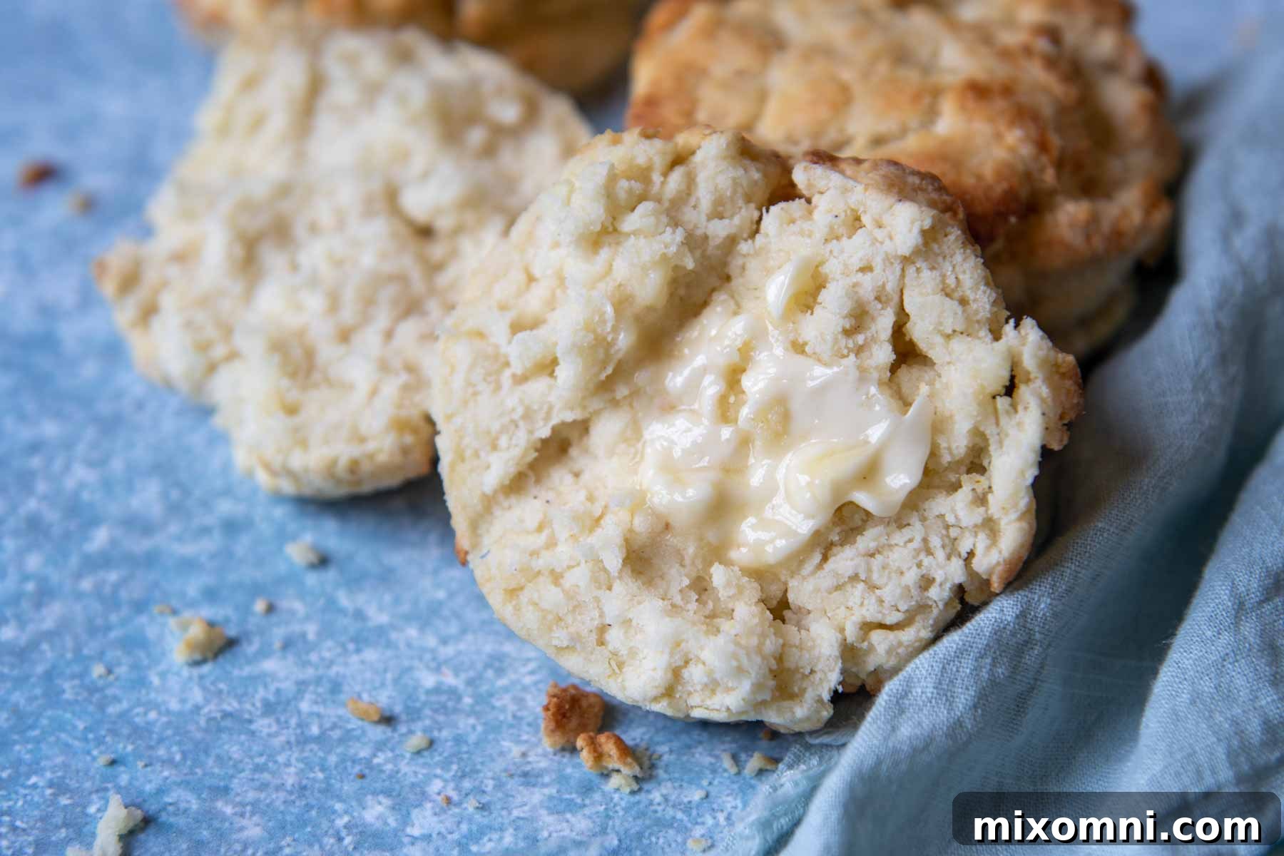 close up of a buttered biscuit on a blue background