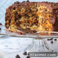 A sliced oatmeal layer cake, revealing its caramel filling and whipped ganache frosting, presented on a cake platter.