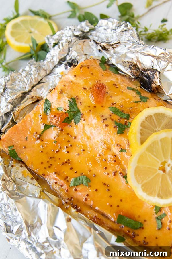 grilled salmon nested in foil with lemon slices laying on top