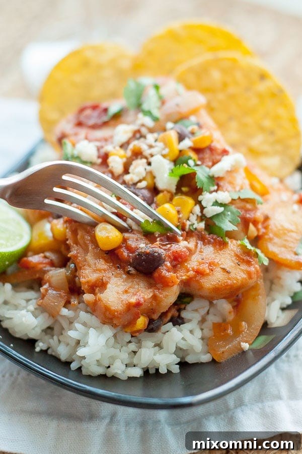 a fork about to cut into a plate of mexican fish served on rice