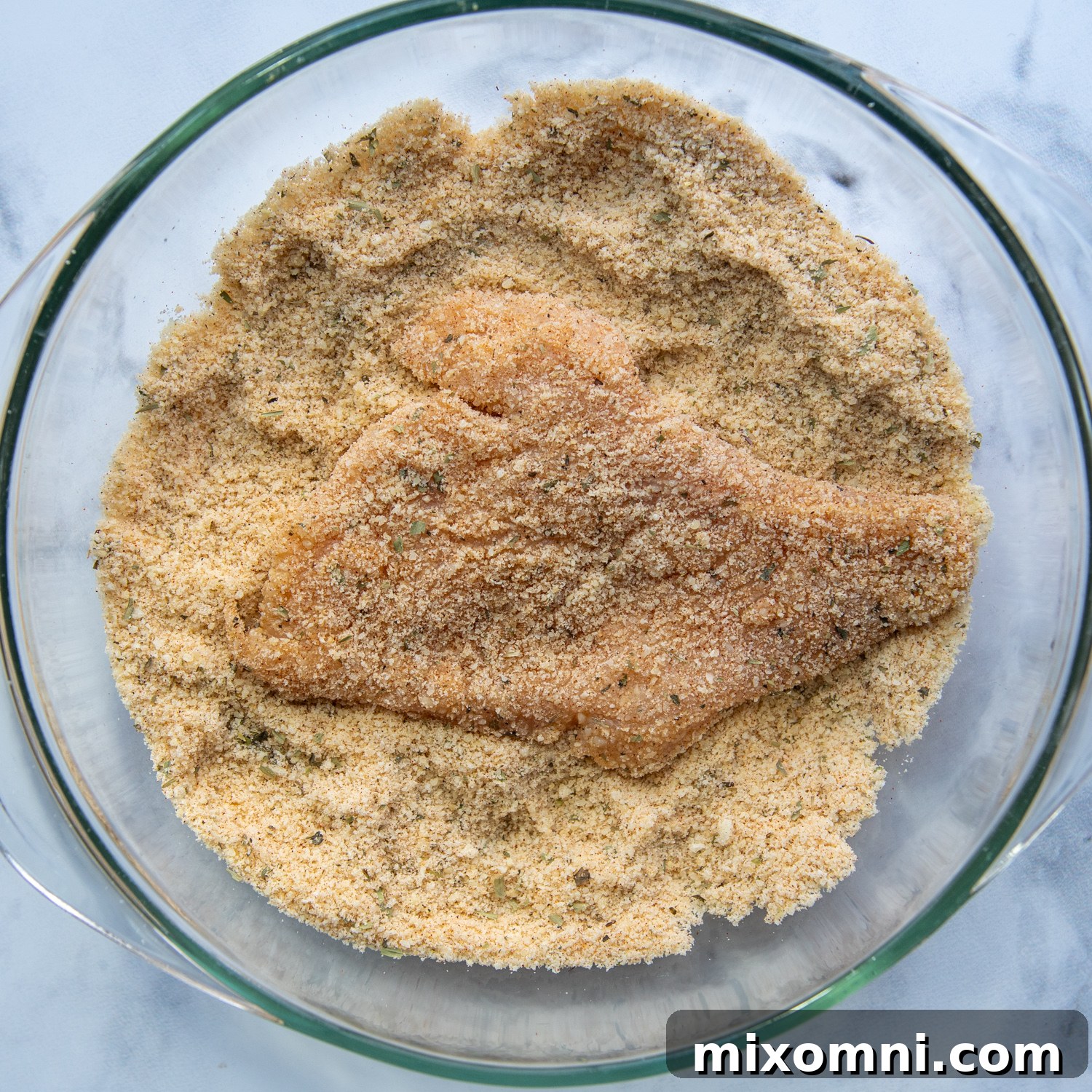 the chicken breaded in almond flour mixture in a bowl.