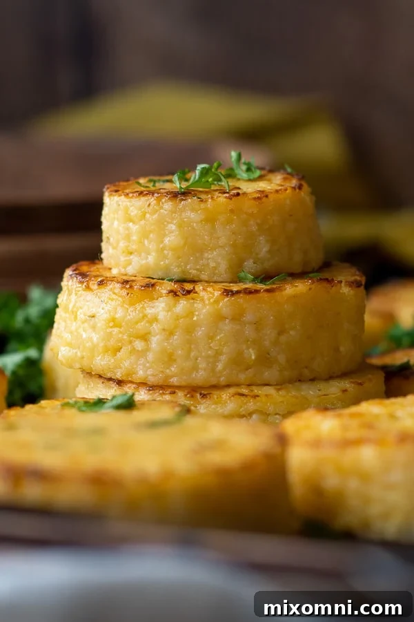 A stack of golden, crispy cheese grit cakes garnished with fresh parsley.
