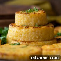 A stack of cheese grit cakes with fresh parsley sprinkled on