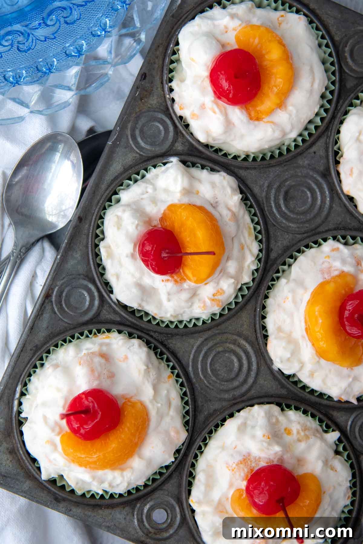 An overhead shot of frozen fruit salad cups artfully arranged in a vintage muffin tin.