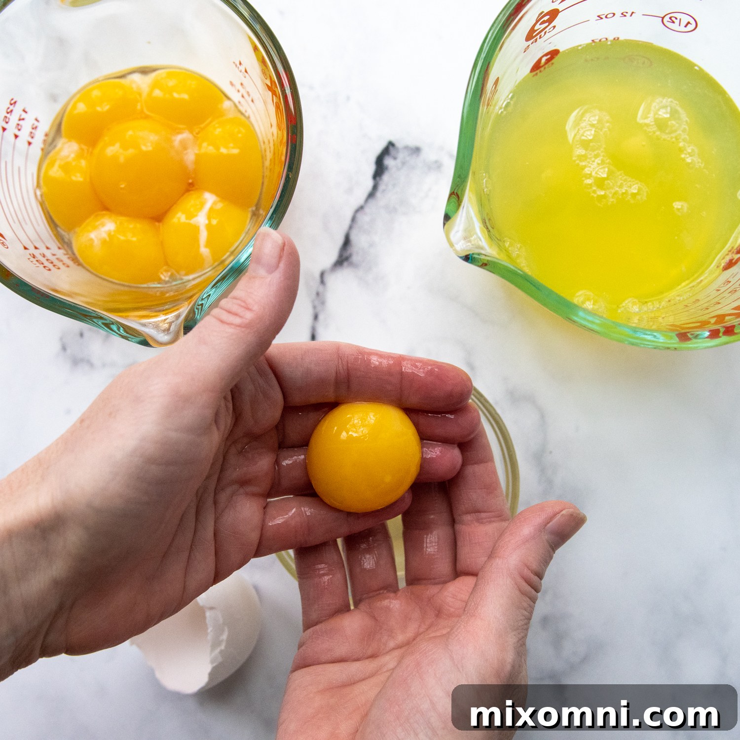 Egg yolks and whites being separated into different bowls.