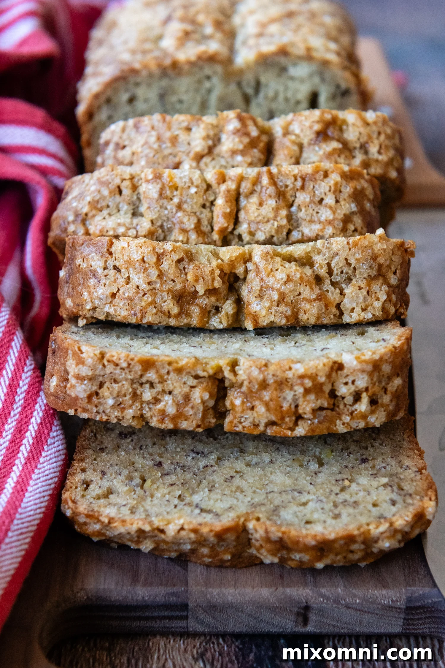 Delicious slices of golden-brown gluten-free banana bread artfully arranged on a wooden cutting board, showcasing its moist, tender crumb.