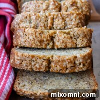 Gluten-free banana bread slices falling onto a wooden cutting board.