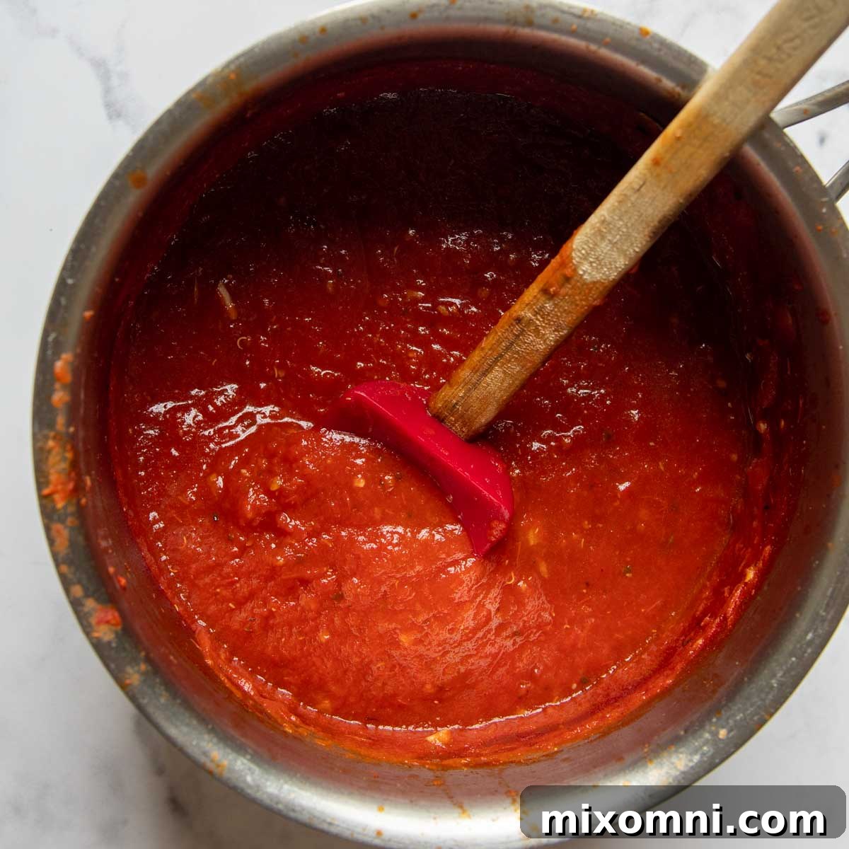 marinara sauce in a pot being stirred.