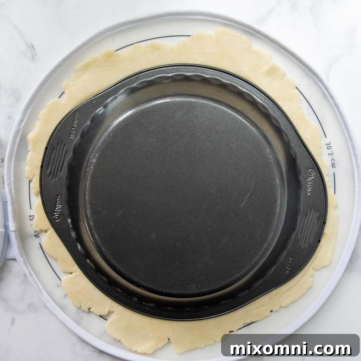 a metal pie pan flipped over on the pie dough.