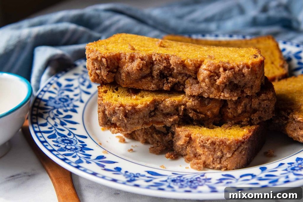 Close-up view of the streusel topping on stacked slices of moist gluten-free pumpkin bread, highlighting the crumbly texture.