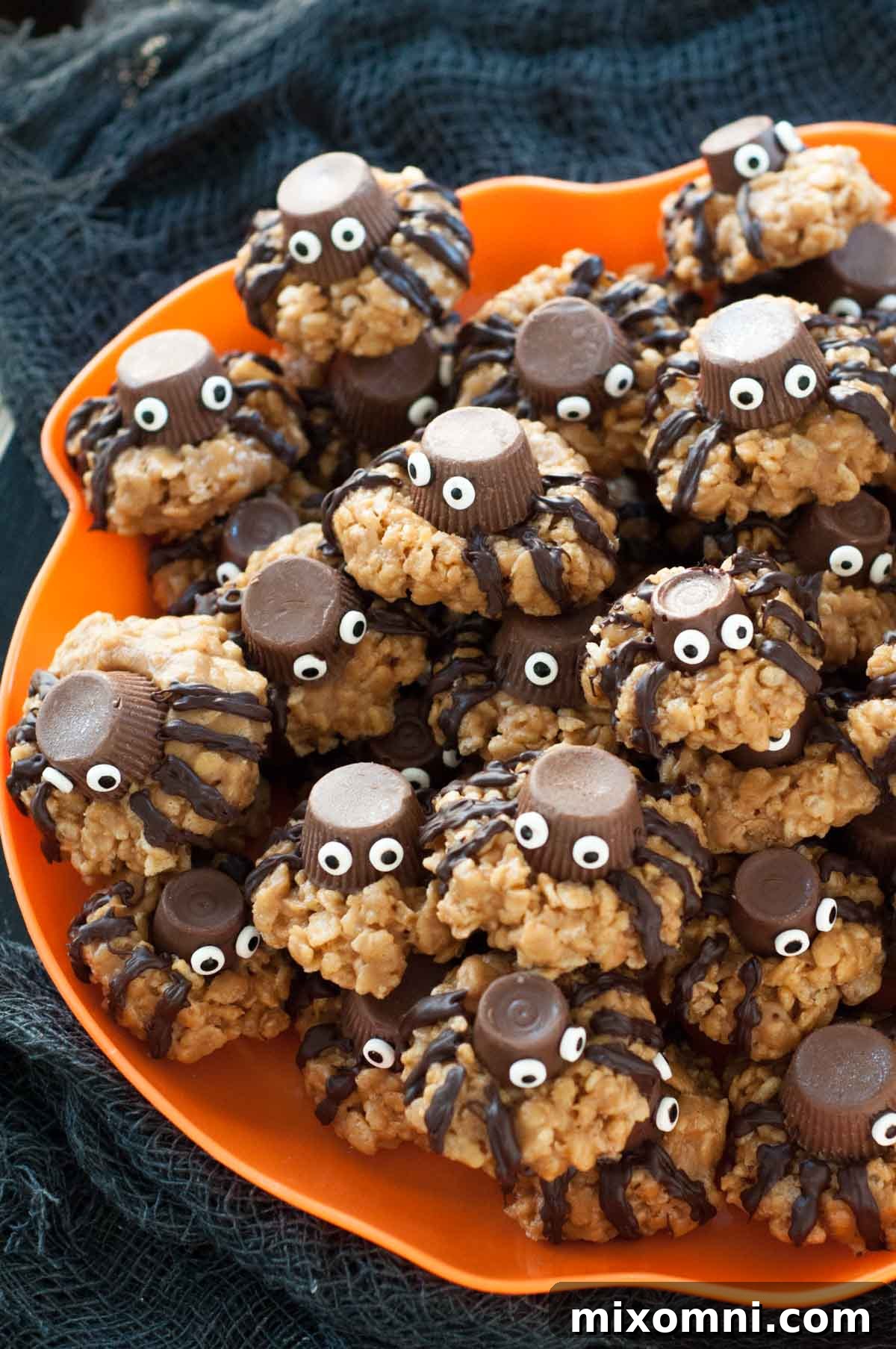 A vibrant orange plate adorned with a collection of charming, gluten-free Halloween spider cookies, perfect for a festive treat.