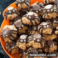A plate of gluten-free Halloween spider cookies on a vibrant orange plate, ready for serving.