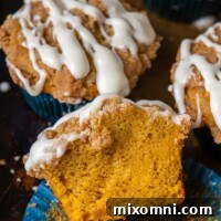 a pumpkin muffin split open and resting on a muffin liner