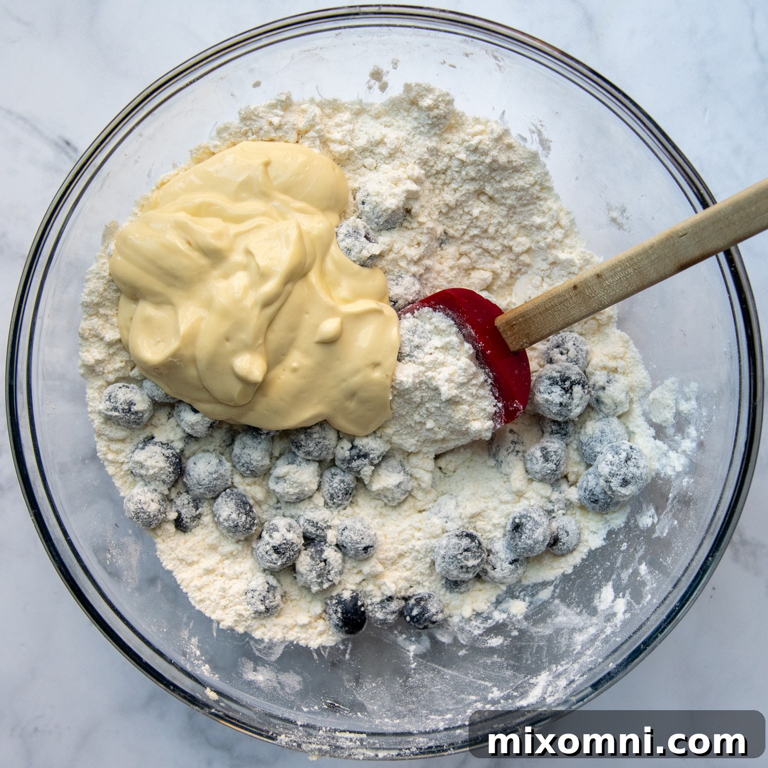 Sour cream and fresh berries being gently folded into the scone dough mixture.