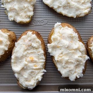 Prepared potato skins, neatly filled with the creamy ranch potato stuffing, ready for their first bake.