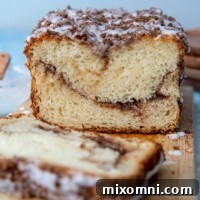 sliced cinnamon swirl quick bread on a wooden cutting board