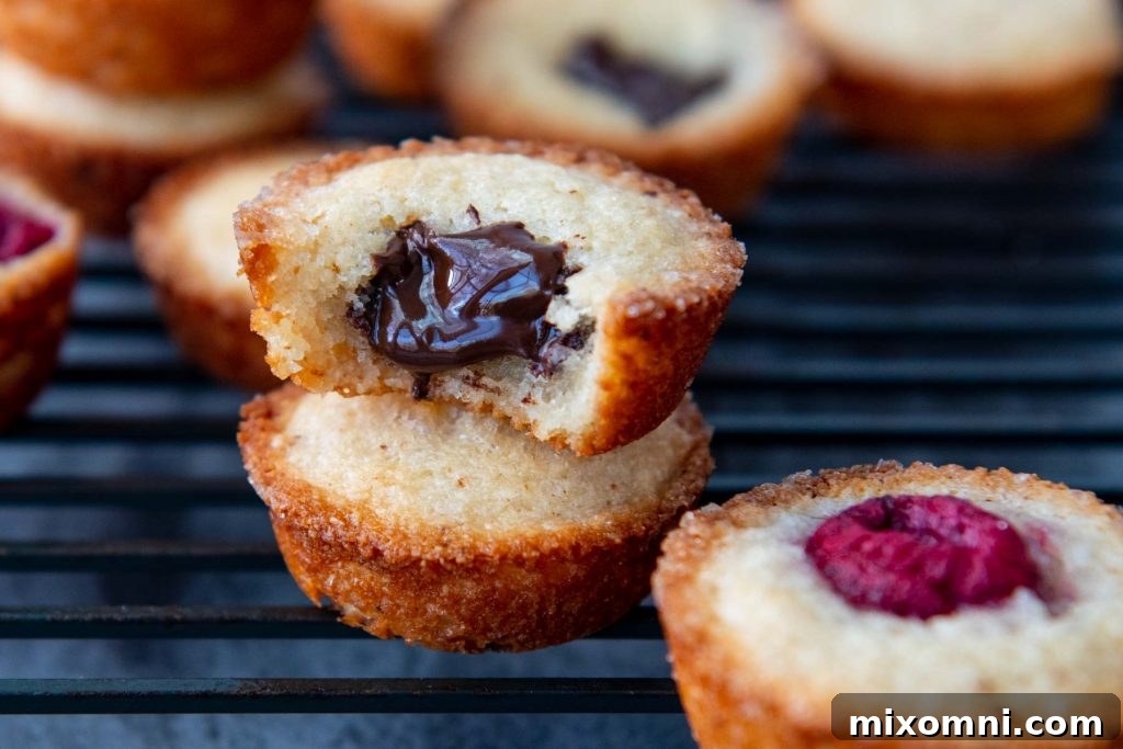 an almond financier with a bite taken out and chocolate coming out