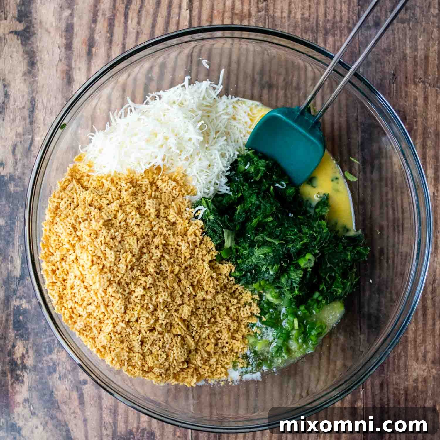 All the vibrant ingredients for the gluten-free spinach balls mixed together in a large glass bowl, ready for shaping.
