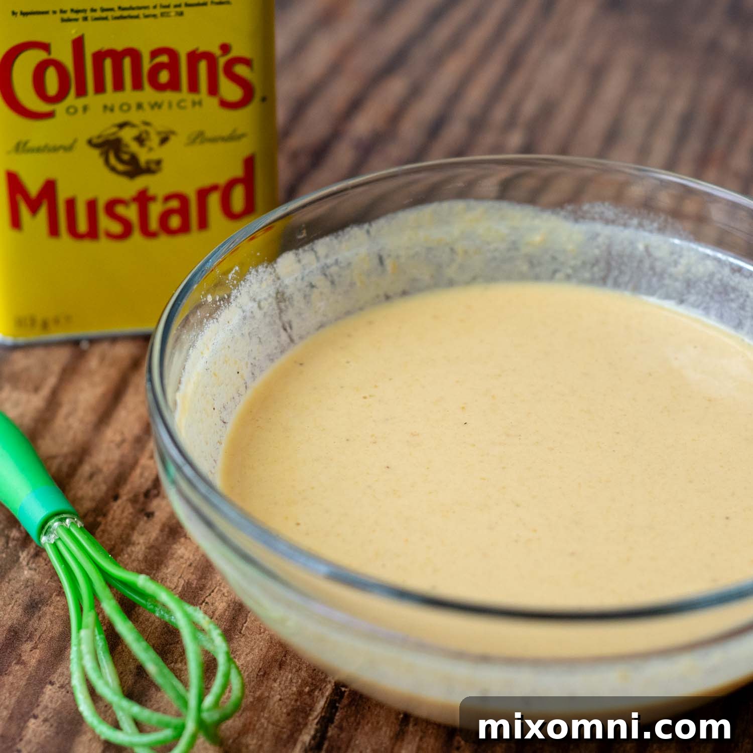 Dry mustard powder and vinegar mixed in a small bowl, beginning the dipping sauce preparation.