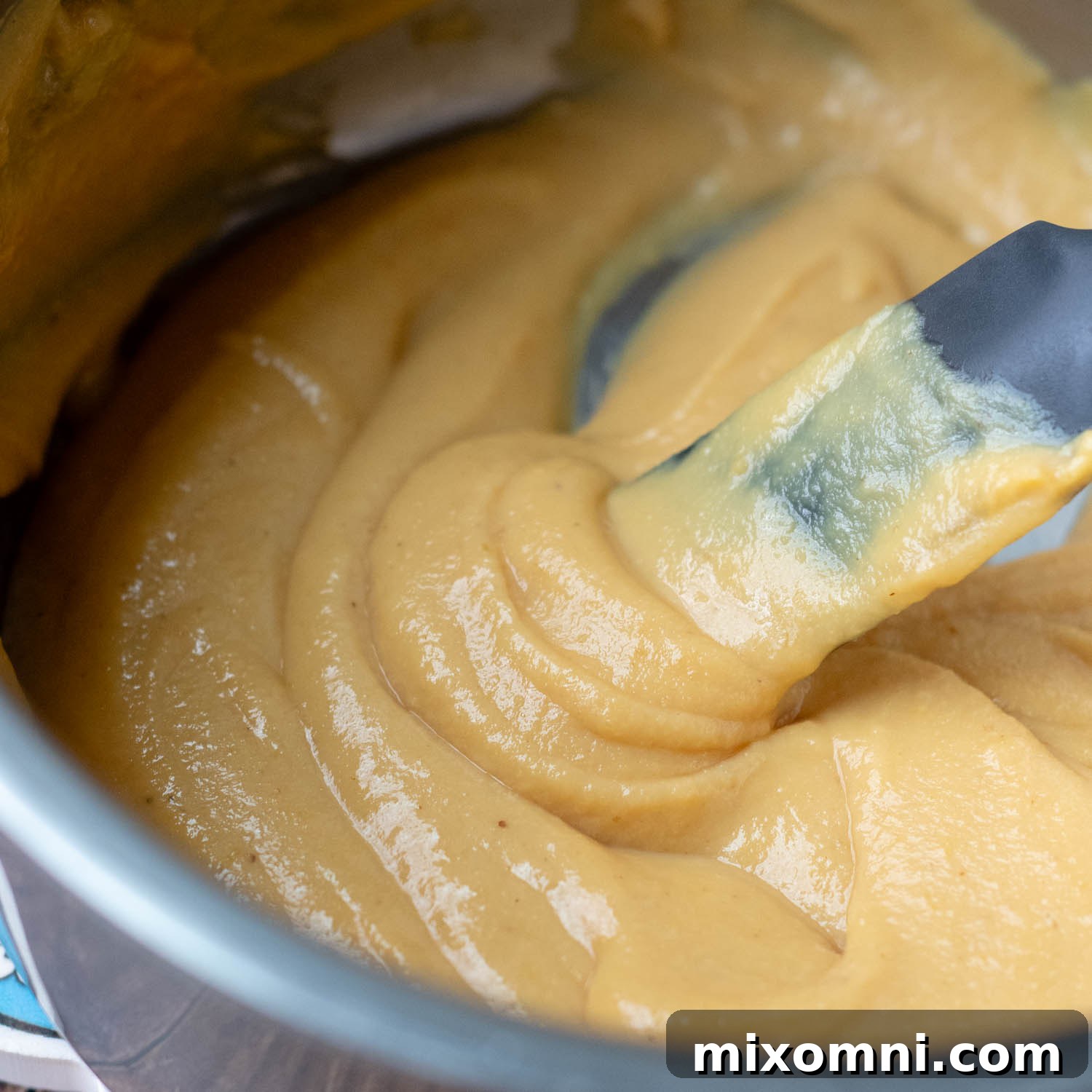 A spoon dipping into the thick, luscious mustard sauce, showcasing its perfect texture.