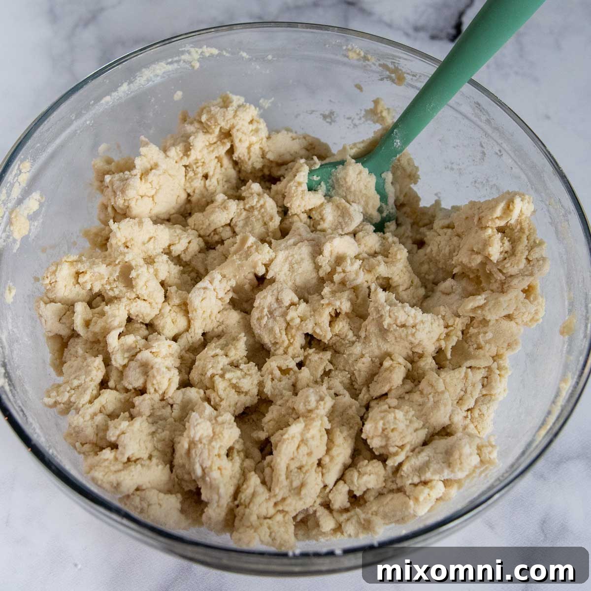 The gluten-free gnocchi dough ingredients are stirred together in a bowl, showing the soft, slightly sticky consistency before shaping.