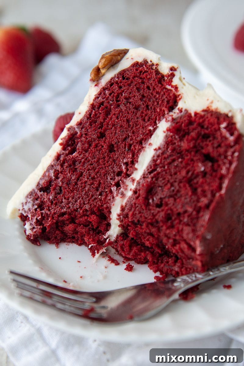 a slice of gluten free red velvet cake on a white plate with bites taken out