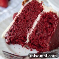 a slice of gluten free red velvet cake on a white plate with bites taken out