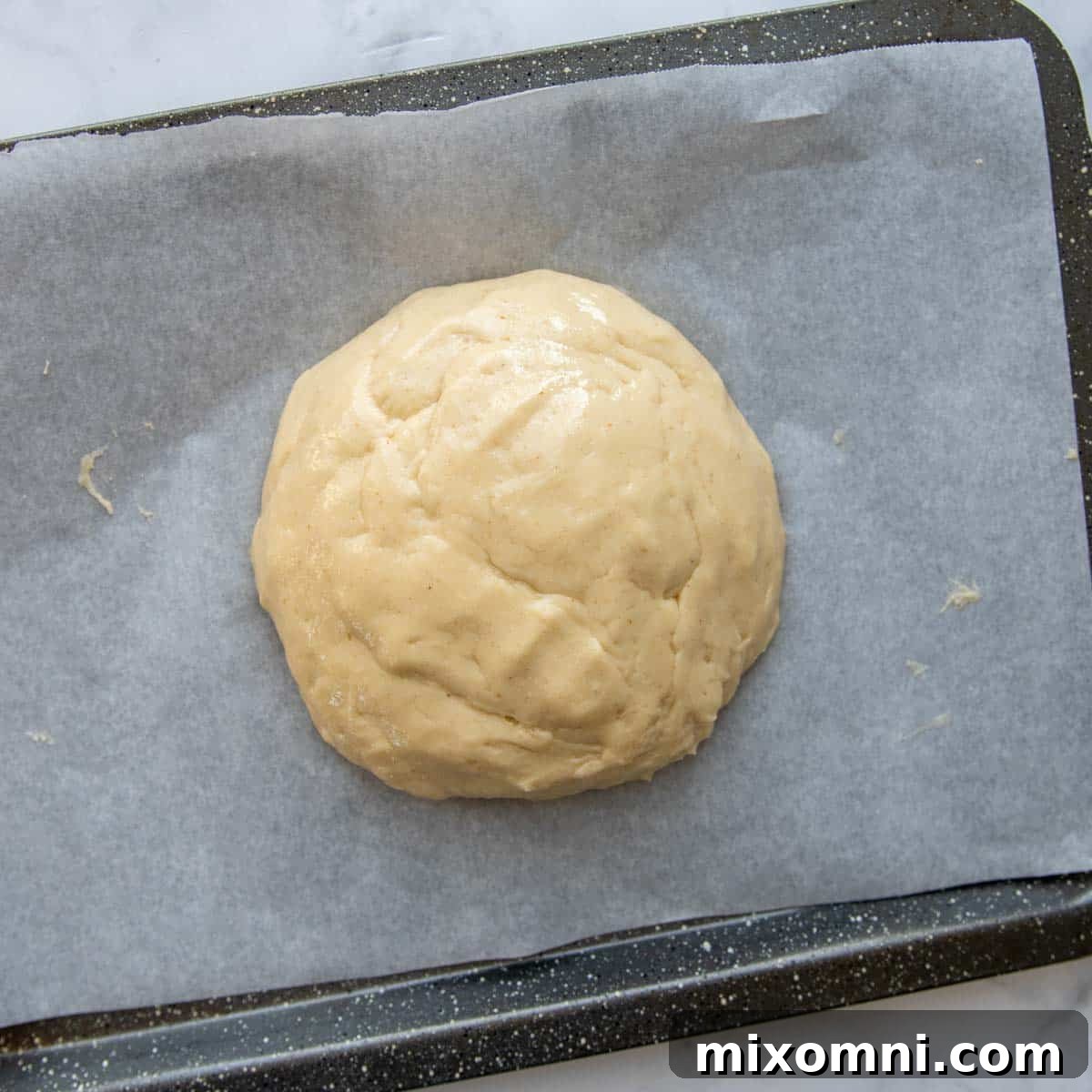 Challah dough resting in a challah mold, ready for its second rise, showing a smooth, even surface.