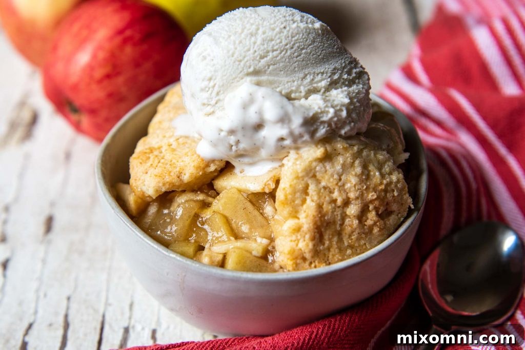 A beautiful landscape view of a generous serving of gluten-free apple cobbler in a white bowl, with a silver spoon resting gracefully beside it, inviting a taste.