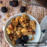 A bowl of homemade gluten-free granola with milk and berries, ready to be enjoyed.