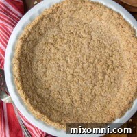 overhead shot of baked oatmeal pie crust in a white plate with a red linen next to it