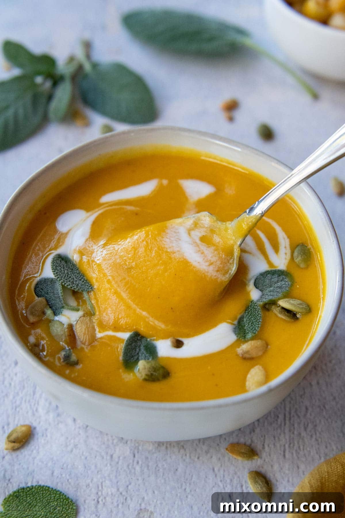 a spoon lifting out a bite of soup from a white bowl