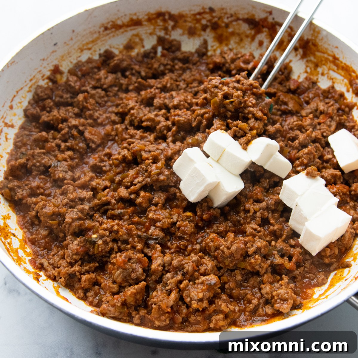 adding the cream cheese to the mixture.