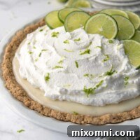 whole gluten free key lime pie in a white pie dish with sliced limes on top