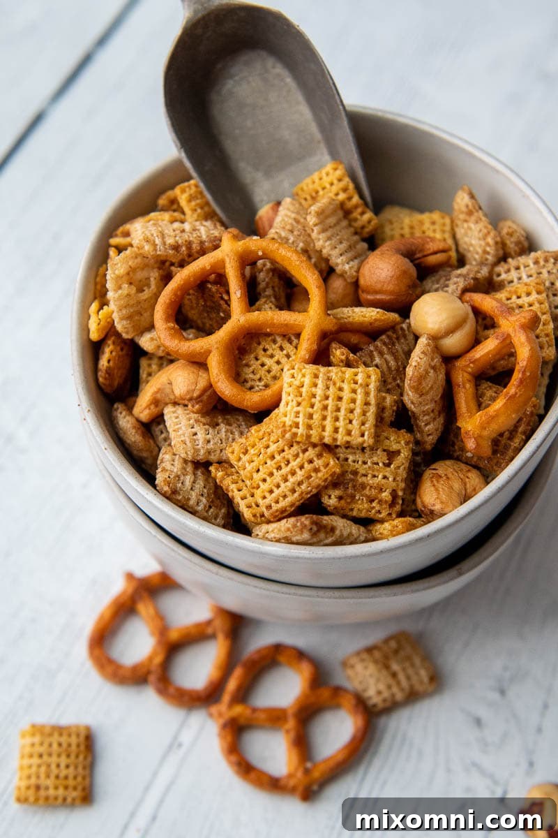 a small bowl of snack mix with a small scoop inside