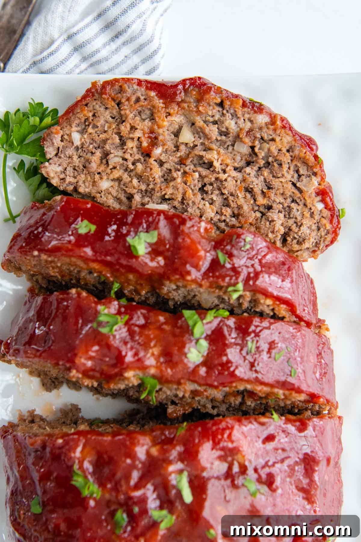 a slice of face up meatloaf on a white plate