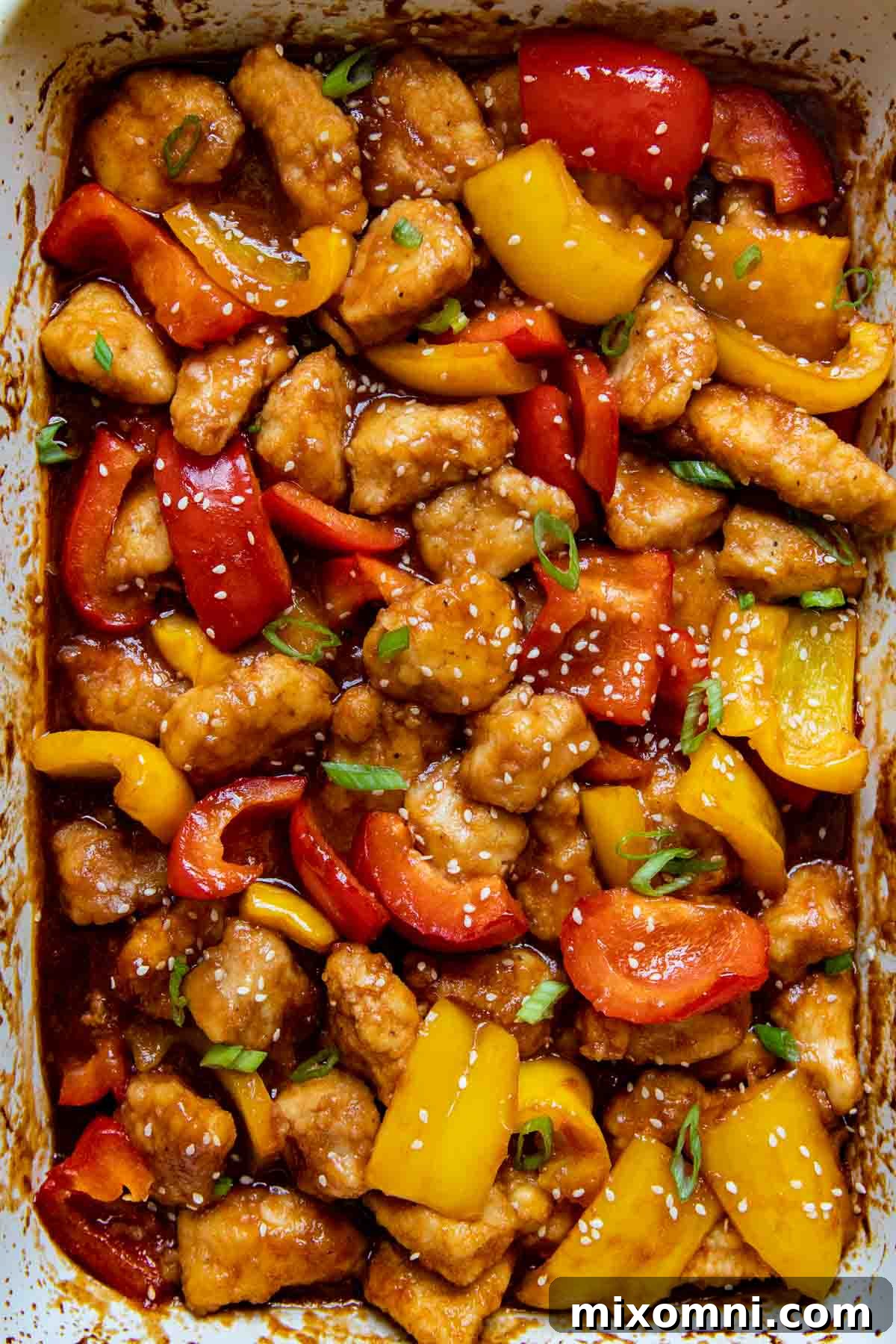 overhead shot of gluten free sweet and sour chicken in a white baking dish