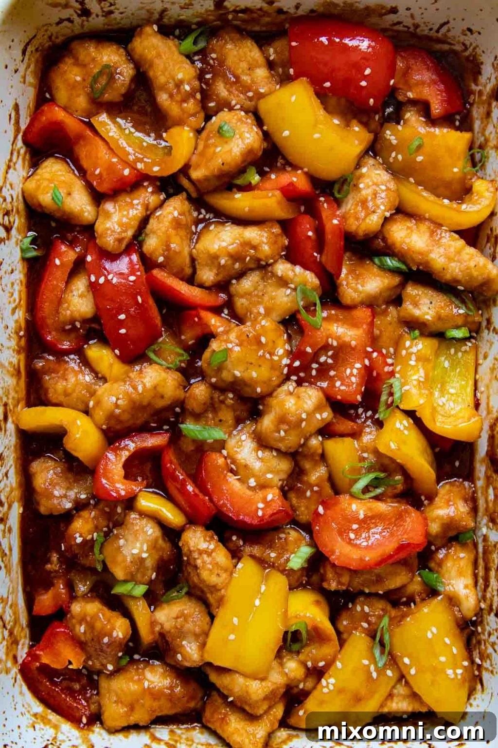 overhead shot of gluten free sweet and sour chicken in a white baking dish