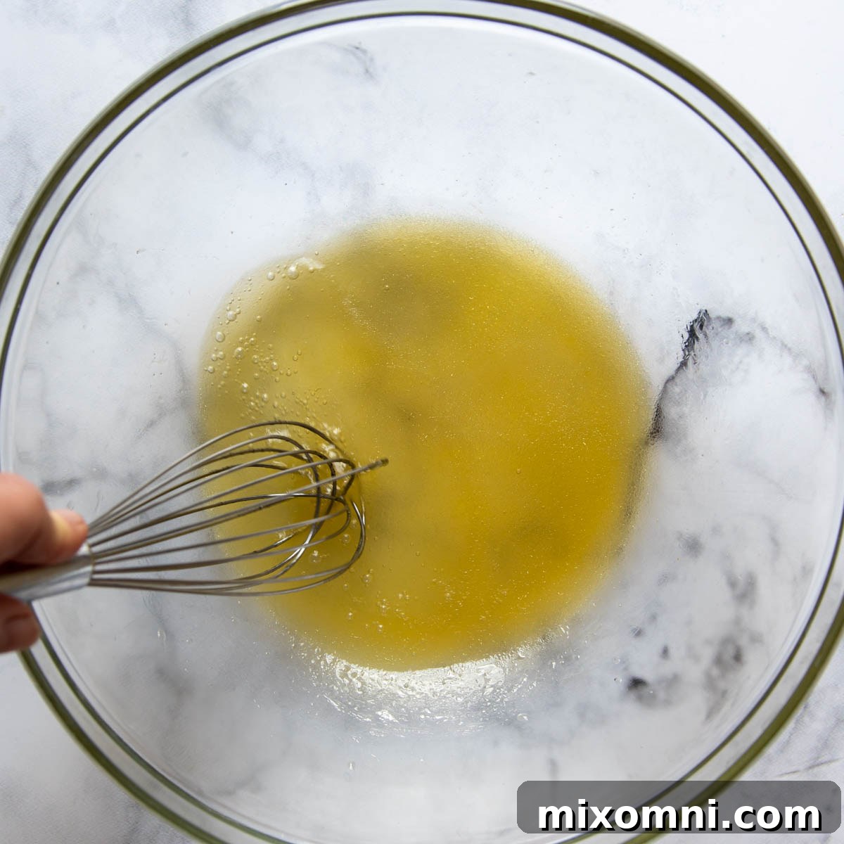 Honey lime slaw dressing being whisked in a small bowl