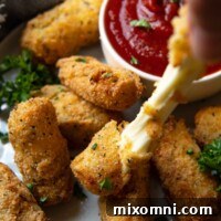 a hand pulling the gluten free mozzarella sticks with cheese pulling out