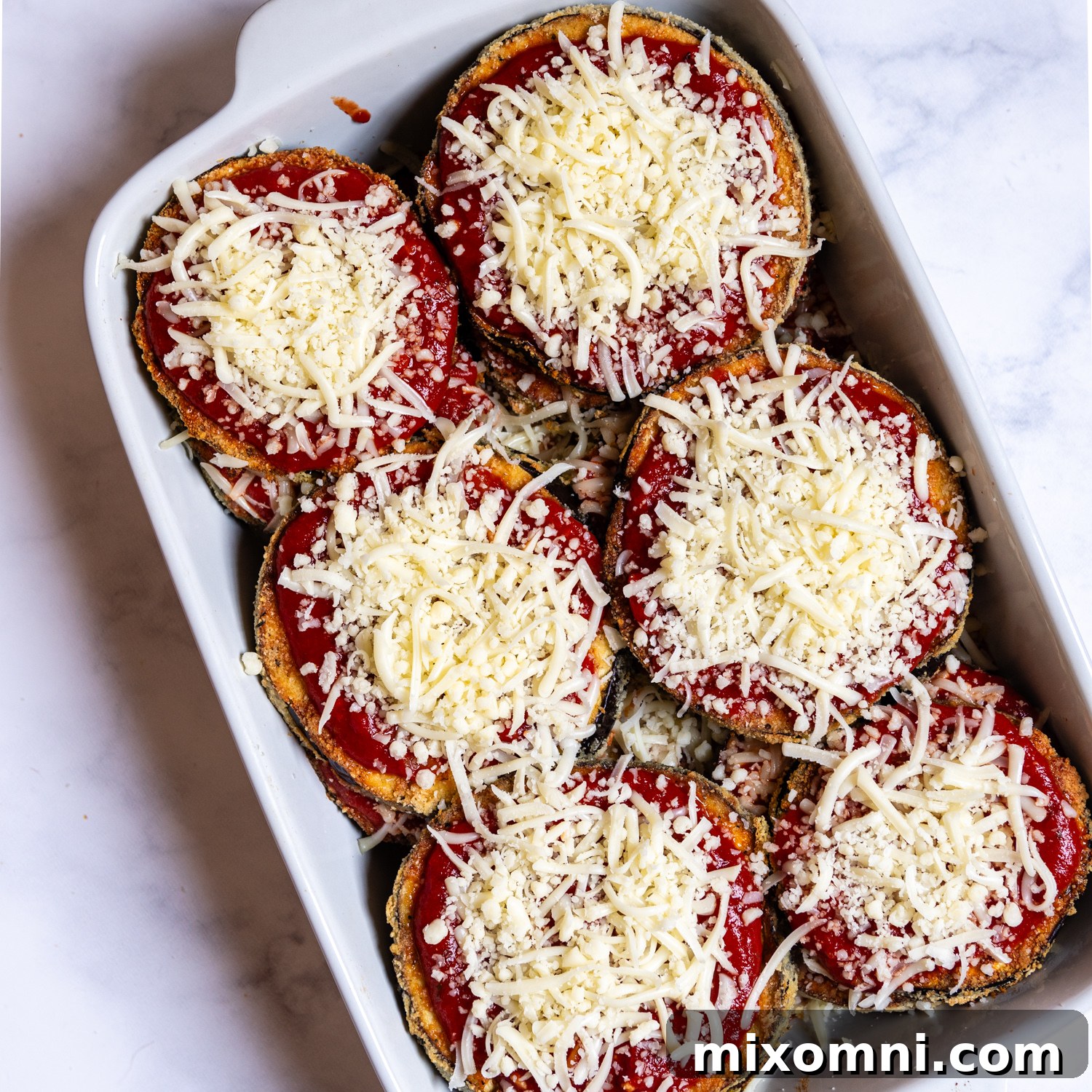 the assembled casserole before baking with grated cheese on top.